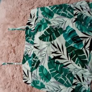 Spaghetti strap top with large green leaves printed.